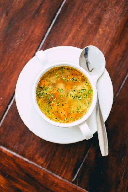 istock Vertical top view of chicken vegetable soup on a wooden table 1455693922