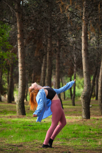 istock Redhead young woman practicing contemporary dance in a forest. 1455694181