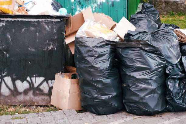 Large pile of household rubbish in black plastic bags near a dumpster in a big city. Large pile of household rubbish in black plastic bags near a dumpster in a big city overflowing dumpster stock pictures, royalty-free photos & images
