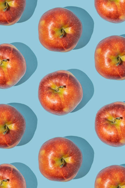 istock Pattern made of fresh red apples on blue background. Minimal fruit concept. 1455696743