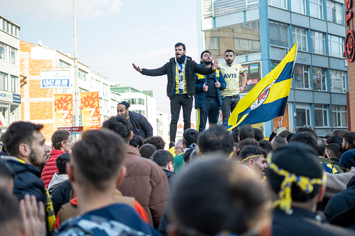 Istanbul, Turkey - January 08, 2023: People enjoying on Kadikoy Square in Istanbul, Turkey. Fenerbahce Sports Club fans having fun together to street before the match.