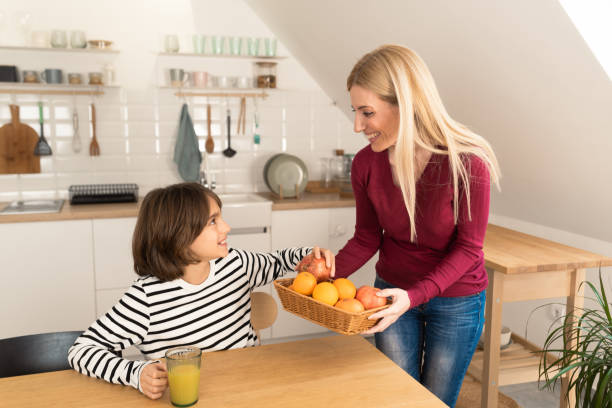 istock Happy boy getting a healthy snack from his mother 1455698528