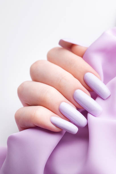 istock Girl's hands with a soft purple manicure. 1455698647