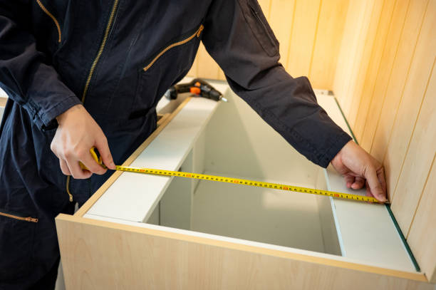 Male hand furniture assembler using tape measure