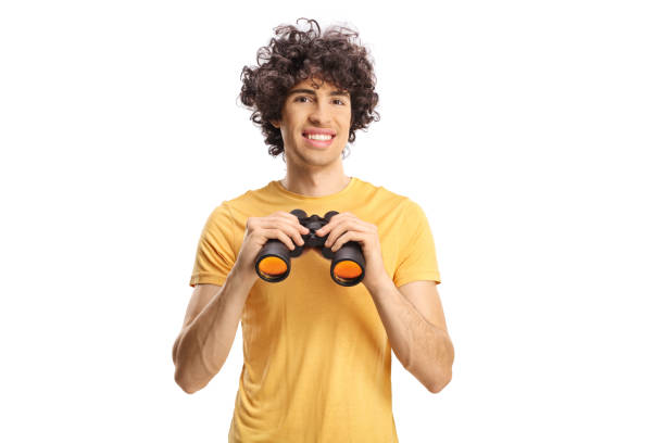Guy with curly hair holding a pair of binoculars stock photo