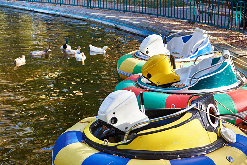 Inflatable play boats in a pond in an amusement autumn park