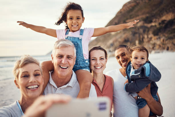plaża, selfie i szczęśliwa duża rodzina na wakacjach razem latem nad morzem w australii. szczęście, dziadkowie i rodzice z dziećmi robiący zdjęcie z uśmiechem na telefonie podczas wakacji w podróży - large family zdjęcia i obrazy z banku zdjęć