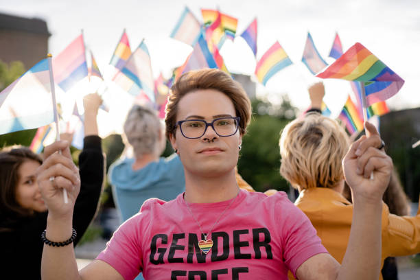istock Trangender man with different LGBTQ+ flags on a pride event 1455701700