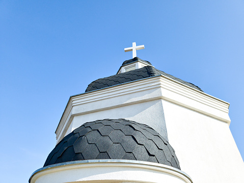 Christian chapel and cross on background blue sky