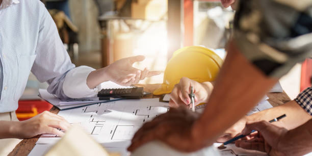 istock Architecture team drawing something while working with blueprint in the office. Architecture and Engineer concept 1455704193