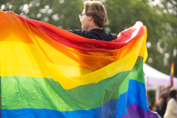 istock Gay man holding large pride flag 1455705089