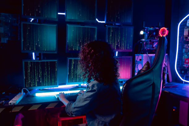 istock Asian hacker in hideout place with dark environment and multiple displays and cables, trying to break into data servers and infect the system with a virus 1455706222