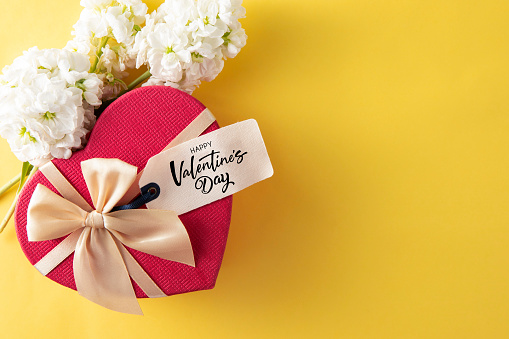 Happy Valentine’s Day gift tag with red heart shaped gift box on yellow background