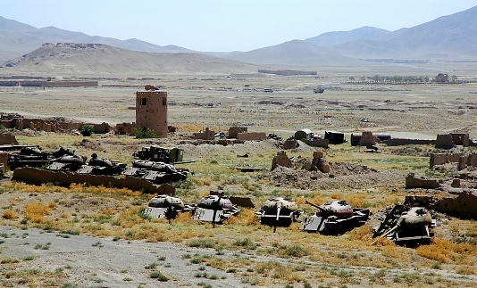 Destroyed tanks and armored vehicles abandoned in a field near Ghazni in Afghanistan. The tanks are close to the famous Ghazni Minarets in central Afghanistan and are a reminder of the Afghanistan war