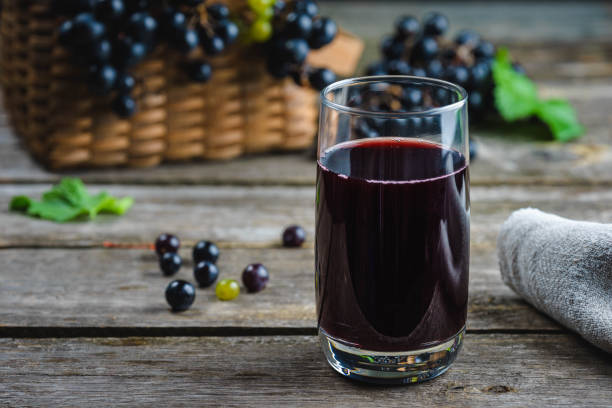 freshly squeezed grape juice on a rustic wooden table. healthy eating stock photo
