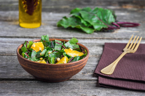 Salad of fresh chard and orange with pine nuts stock photo
