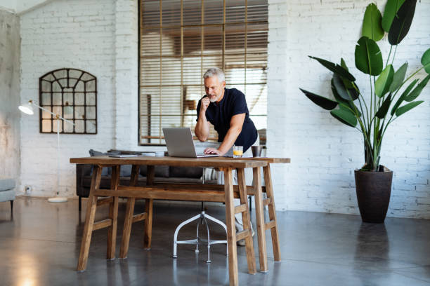 istock Senior businessman working in modern bright office. Mature entrepreneur using laptop for work 1455708725
