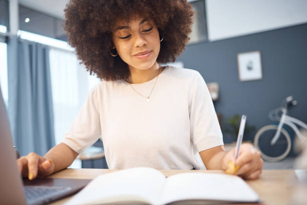 istock Student research, writing notes and black woman remote eduction on a home computer. Working, planning and reading digital learning busy with tech data test elearning and web university information 1455709462
