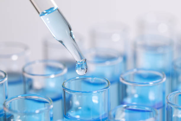 istock Dripping reagent into test tube on light background, closeup and space for text. Laboratory analysis 1455709811
