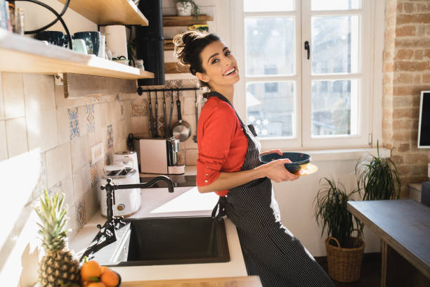 Young woman doing dishes at her kitchen stock photo