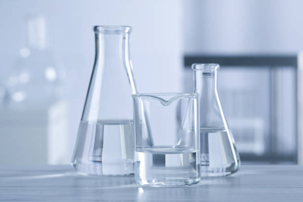istock Different laboratory glassware with transparent liquid on wooden table against blurred background 1455710253