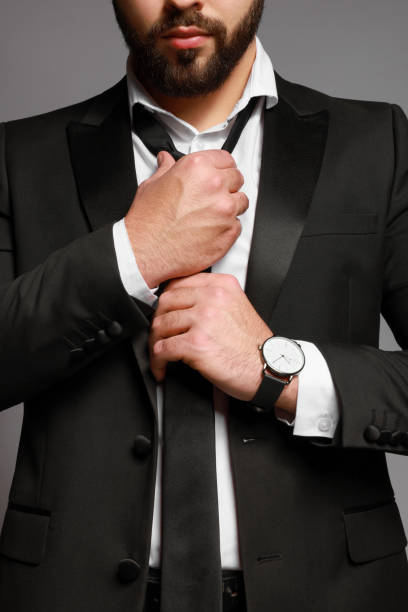 istock Bearded man tightening tie on grey background, closeup 1455711515
