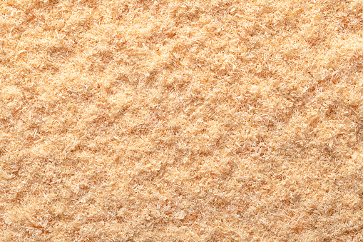 Wood flour, wood powder, fine sawdust, close-up, surface from above. Formed by sawing dried spruce. Finely pulverized wood, a by-product and waste product, mainly used as a filler and extender.