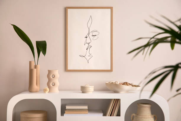 istock Interior design of aesthetic and elegant room with mock up poster frame, white commode, plants, book, decoration, vase with leaf and personal accessories. Stylish home decor. Template. 1455713474
