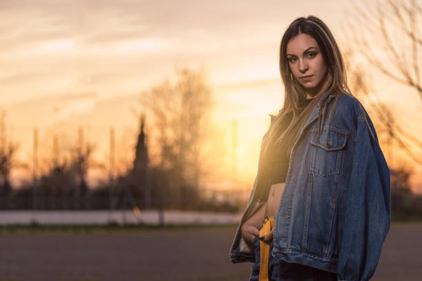 Portrait of young blonde woman posing looking at camera with denim jacket stock photo
