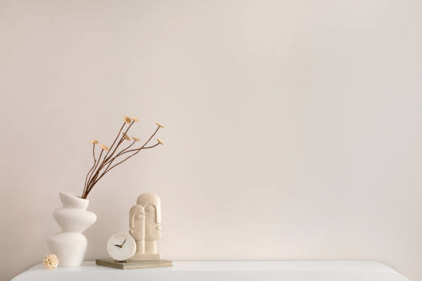 istock Minimalist composition of elegant and outstanding space with copy space, vase with dried flowers, beige sculpture and personal accessories. Home decor. Template. 1455713596