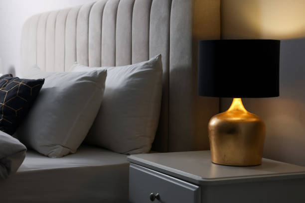 istock Stylish lamp on bedside table indoors. Bedroom interior element 1455714111