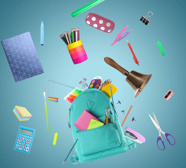 istock Turquoise backpack, school bell and different stationery flying on light blue background 1455714118