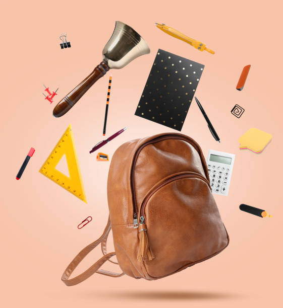 istock Leather backpack, school bell and different stationery flying on beige background 1455714122