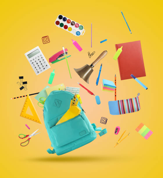 istock Turquoise backpack, school bell and different stationery flying on yellow background 1455714161