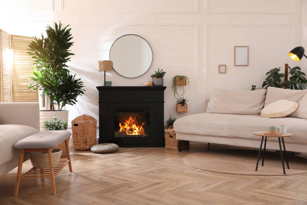 Stylish living room interior with electric fireplace, comfortable sofas and beautiful decor elements