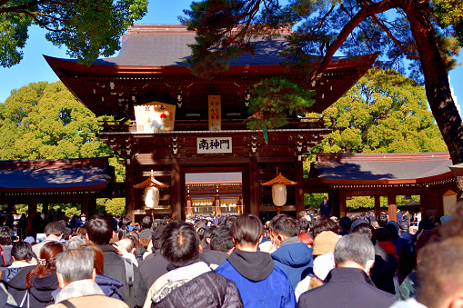 Tokyo, Japan-January 4, 2023:\nA big crowd under the police traffic control is walking through the South Sacred Gate (Romon Gate) of Meiji-Jingu Shrine to enter the ground of the Main Hall. During the New Year season, the gate is elaborately decorated to welcome the year with various signs, including the picture of Oriental zodiac. The year 2023 is year of the rabbit.\nAbout 3 million people visit Meiji-jingu Shrine during the three days of New Year, to pray for their health and good luck for the year.\nMeiji-Jingu Shrine, a Shinto shrine, was established in 1920 and dedicated to Emperor Meiji (1852-1914) and his consort Empress Shoken (1850-1914); the great grand parents of the current Emperor Naruhito.\nAll visitors, as it has now become customary, wear protective face mask to prevent Corona virus pandemic.