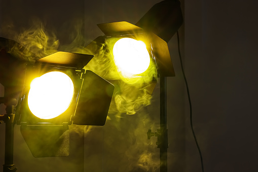 Bright yellow spotlights near wall indoors. Professional stage equipment