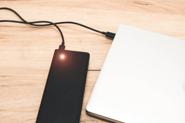 istock Power bank with usb-c cable is charging laptop . Modern, information technology. 1455715699