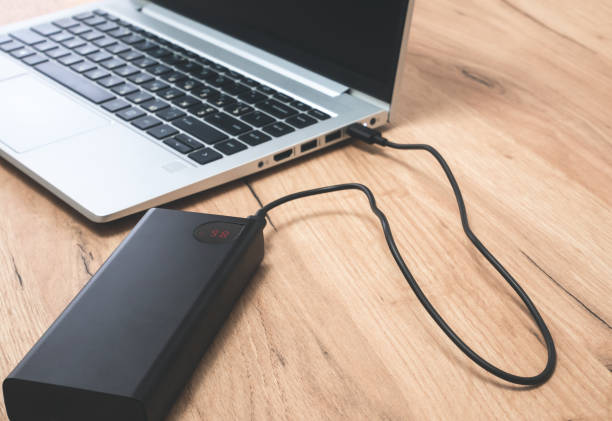 istock Power bank with usb-c cable is charging laptop . Modern, information technology. 1455715743