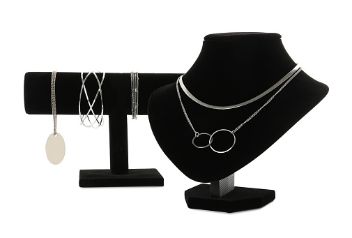 Different display stands with stylish jewelry on white background