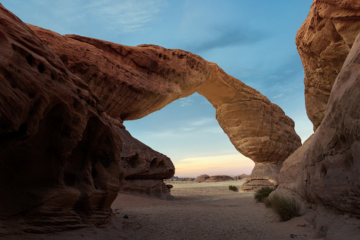The Arch rock in Valley of Fire is a famous landmark in this red rock desert landscape in Nevada, USA. Seen a hot summer day.