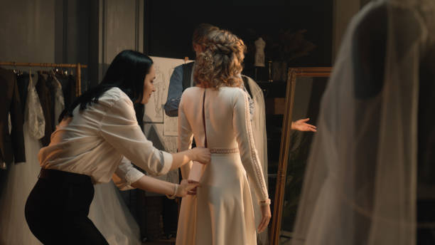istock Tailor zips up wedding dress on woman 1455719908