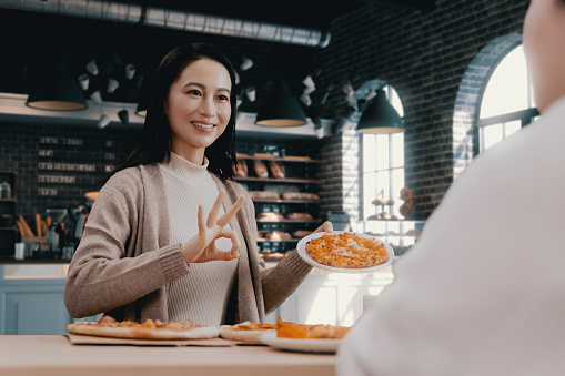 female hand holding slice of pizza