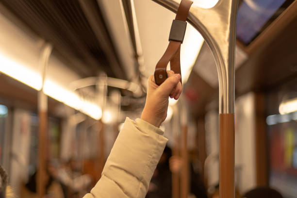 istock Hand holding the handle in tram, train, bus or subway. Passenger standing in public transportation 1455721117