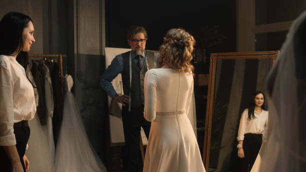 istock Tailor zips up wedding dress on woman 1455721122