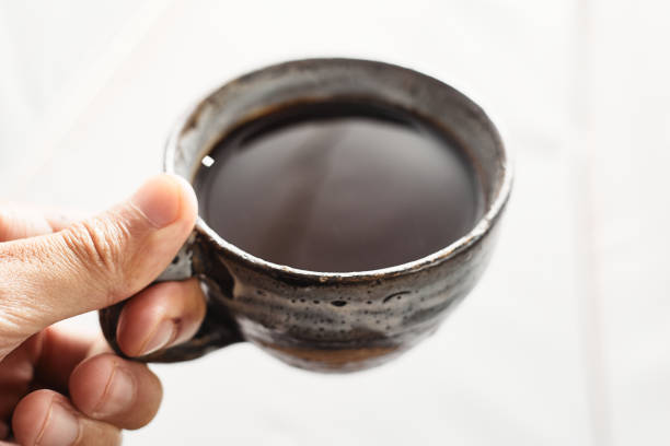 istock Hand of a man holding a cup with hot black coffee 1455722964