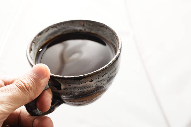 istock Hand of a man holding a cup with hot black coffee 1455722991