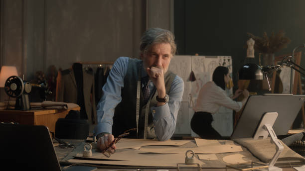 istock Tired male tailor sits at table in atelier 1455723276