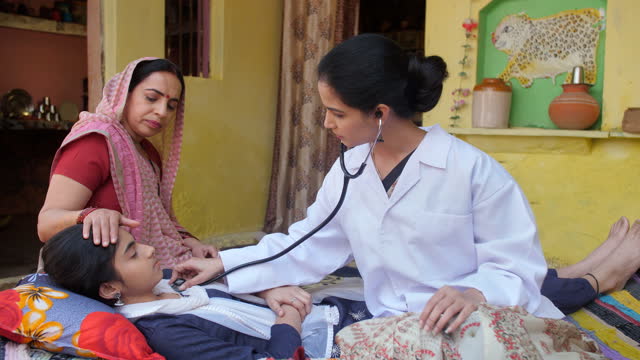 A middle-aged lady doctor doing a checkup of a teenage girl - medical attention, Anganwadi worker, healthcare in an Indian village