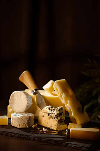 Cheese variety, many different types of cheeses on black background.